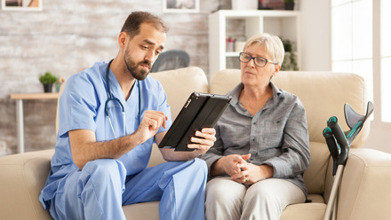 Male doctor tablet patient